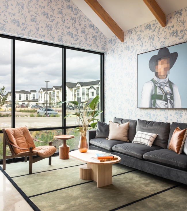 Resident lounge at The Prado apartments for rent in Austin, TX, featuring couches and floor to ceiling windows.